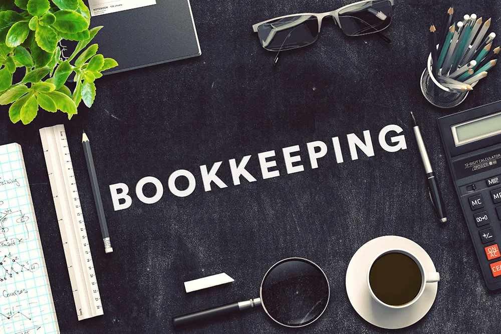 Bookkeeping desk with calculator, ledger and coffee